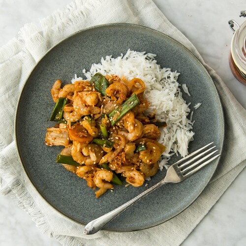 Un assiette de sauté aux crevettes et au kimchi posé sur une serviette.