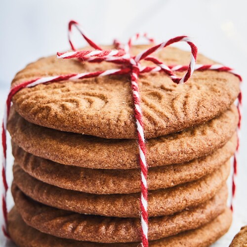 Des biscuits spéculoos attachés avec de la ficelle rouge et blanche.