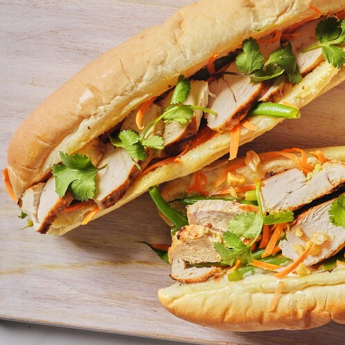 Deux sandwichs au poulet asiatique sur une planche.