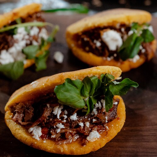 Plusieurs arepas au bœuf effiloché prêts à être dégustés.