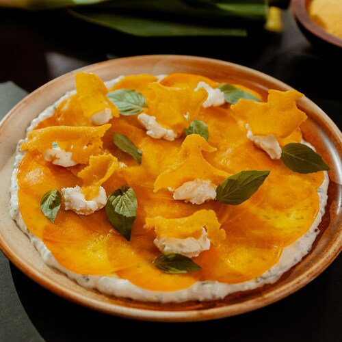Un carpaccio de betteraves au fromage de chèvre garni de basilic et de croustilles de polenta.
