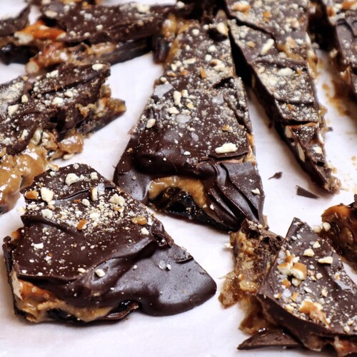 Des écorces de chocolat et de dattes aux bretzels sur un papier parchemin.