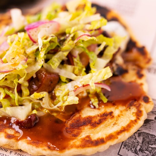 Un gyros d'agneau garni de salade et d'oignon rouge.