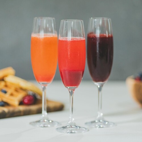Trois verres de mimosa aux fruits québécois sur un comptoir de cuisine.