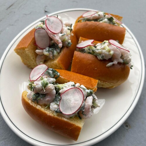 Des petits sandwichs aux crevettes nordiques dans une assiette.