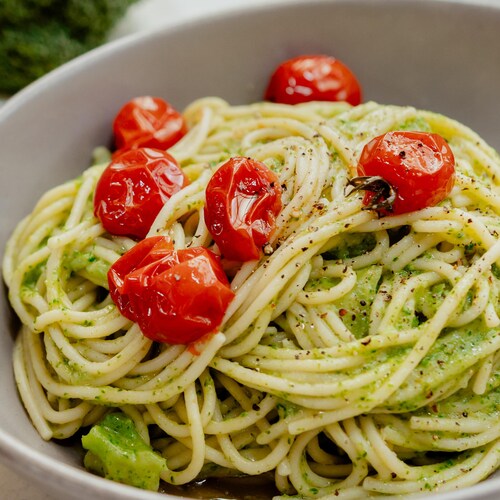 Un plat de spaghettis et sauce au brocoli, avec des tomates cerises confites.