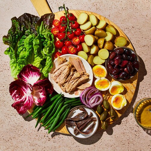 Un plateau pour l'apéro avec tous les ingrédients d'une salade niçoise.