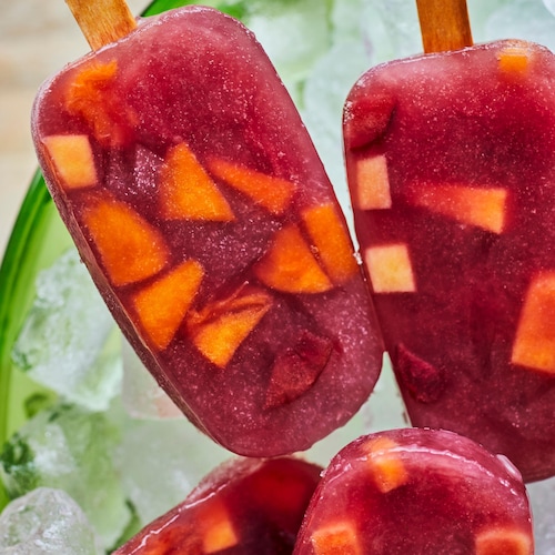 Deux pops glacés à la sangria dans de la glace.
