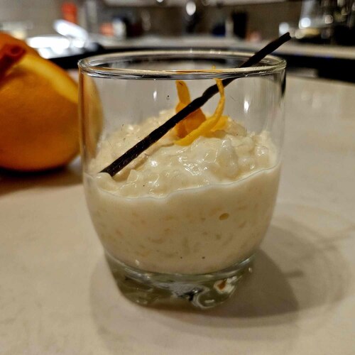 Un petit contenant en verre de riz au lait à l'orange et à la vanille.