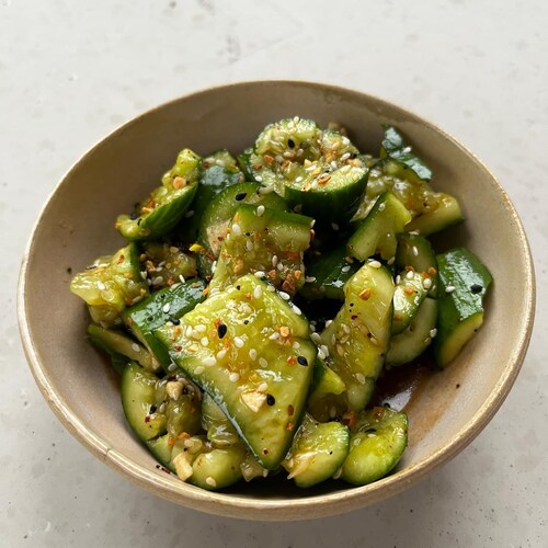 Un bol de salade de concombres écrasés posé sur un comptoir.