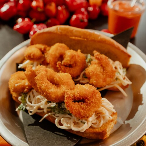 Un sandwich po boy aux crevettes et au céleri-rave dans une assiette.