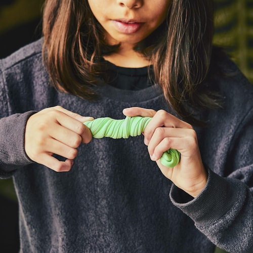Une jeune fille tient de la slime dans ses mains. 