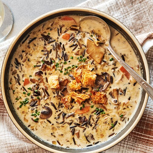 Un bol de soupe crémeuse aux champignons et au riz sauvage.