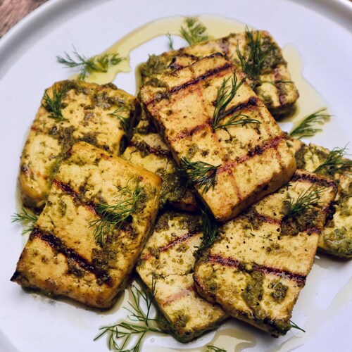 Des tranches de tofu grillé garnies d'huile d'olive et d'aneth frais.