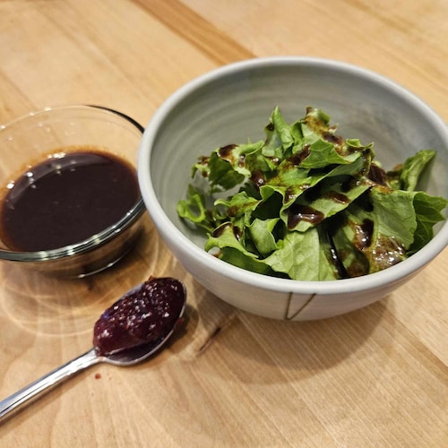 Une salade verte arrosée de vinaigrette à la confiture aux framboises.