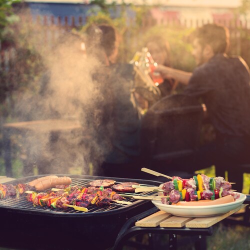 Des brochettes de viande et de légumes sur un barbecue pendant une fête.