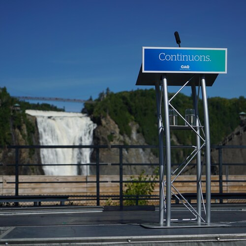 Un lutrin vide aux couleurs de la CAQ devant les chutes Montmorency.