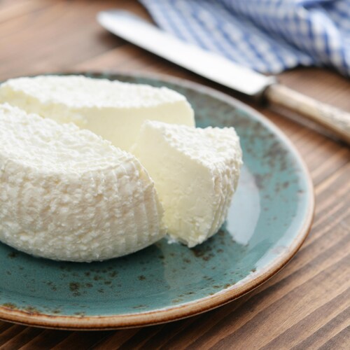 Une meule de fromage frais sur une assiette.