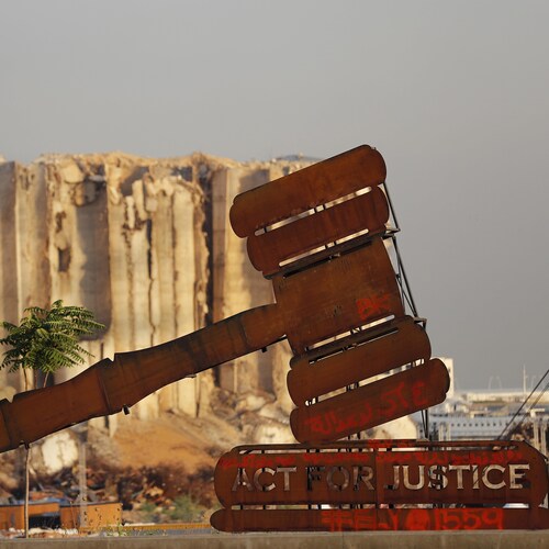 Un monument représentant un maillet avec l'inscription «Agir pour la justice» est installé devant les silos détruits du port de Beyrouth.