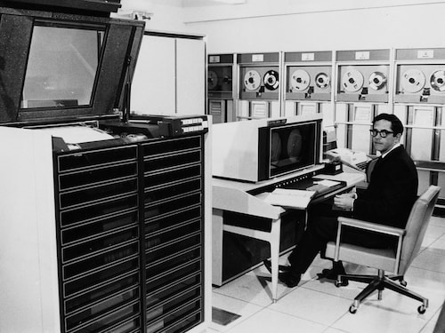 Un homme assis devant un ordinateur dans une salle informatique du Centre de calcul de l'Université de Montréal.