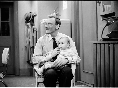 Jean-Louis Roux avec un bébé sur les genoux. 