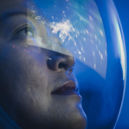 Astronaute regardant la terre à travers la fenêtre d'une navette.