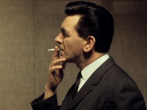 Image de profil en couleurs de Camille Laurin fumant une cigarette. 