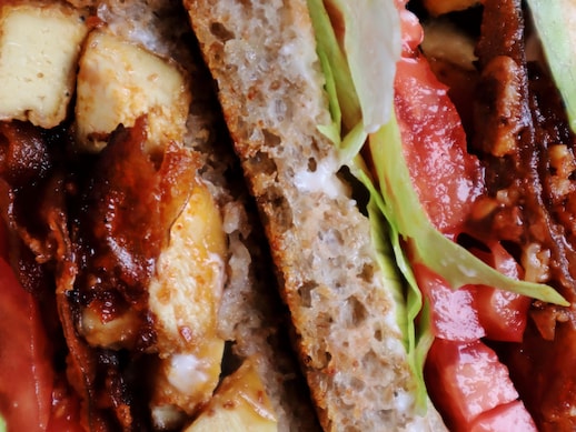 Gros plan sur une moitié de sandwich style BLT vu de côté avec toutes ses garnitures, dont le bacon végétalien facile!