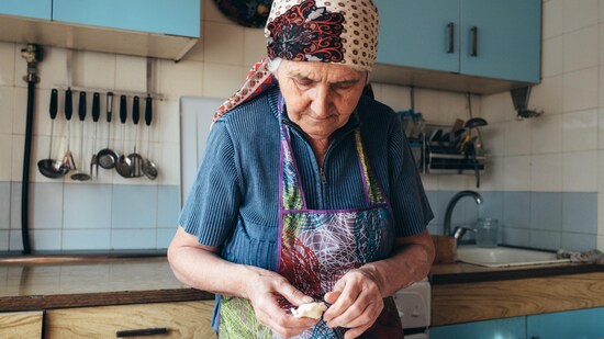Une vieille dame travaille la pâte. 
