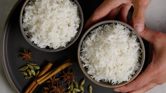 Riz cuit dans deux bols avec des aromates sur le côté.