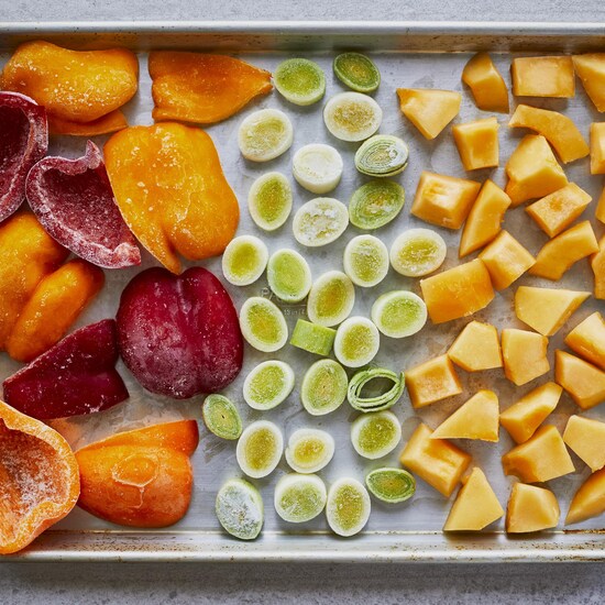 Des poireaux, des poivrons et de la courge, congelés sur une plaque de cuisson. 