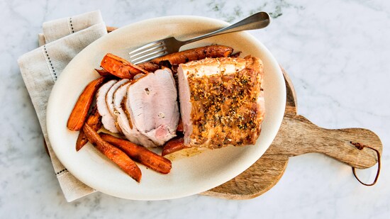 Un rôti de porc dans une assiette avec des carottes rôties.