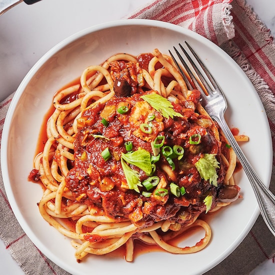 Une assiette remplie de spaghetti à la sauce aux tomates grillées et au thon.