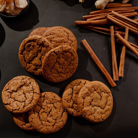 Plusieurs biscuits au gingembre avec des bâtons de cannelle et du gingembre.