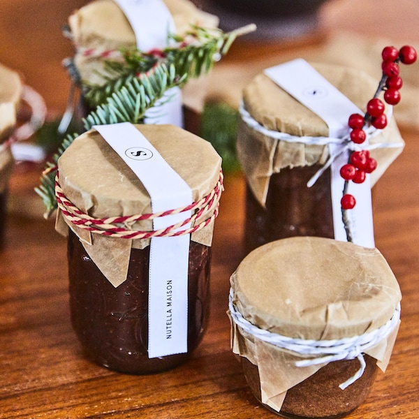 Quatre petits pots sont ornés de décorations de Noël. 

