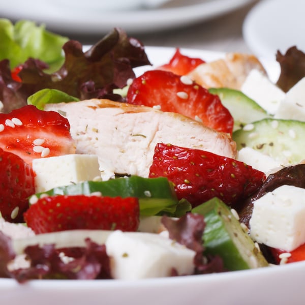 Une salade vu de près avec fraises, concombres, oignon et feta.