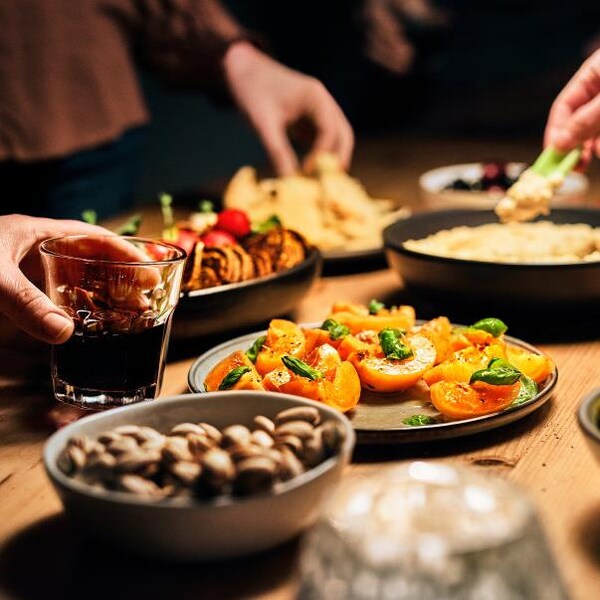 Des personnes choisissent différentes entrées posées sur un îlot de cuisine. 