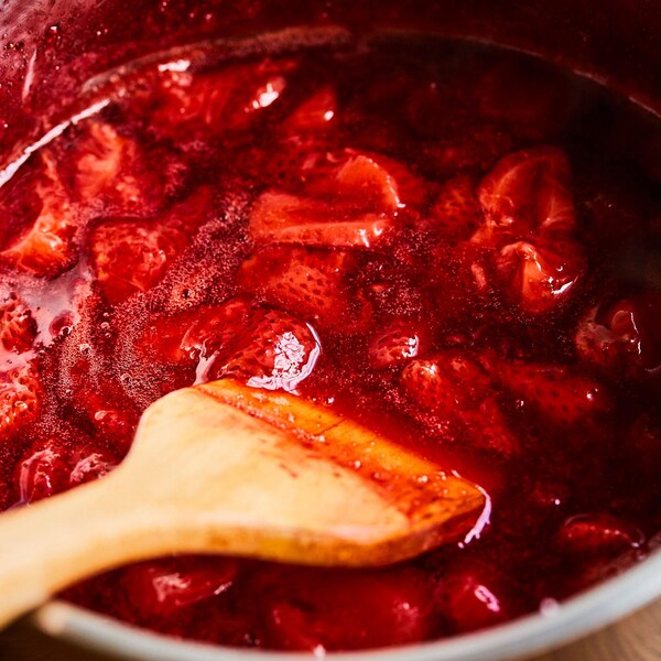 Un chaudron de confiture aux fraises avec une spatule. 