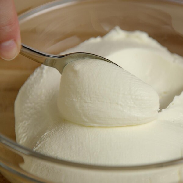 Une cuillère dans un bol contenant de la mascarpone. 