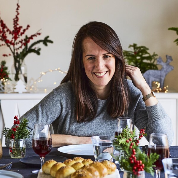 Geneviève est assise à la table, entouré de décorations de Noël.