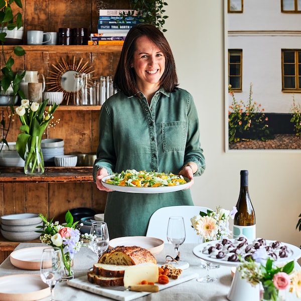 La nutritionniste Geneviève O'Gleman est debout derrière une table et tient une assiette contenant une salade de fenouil. 