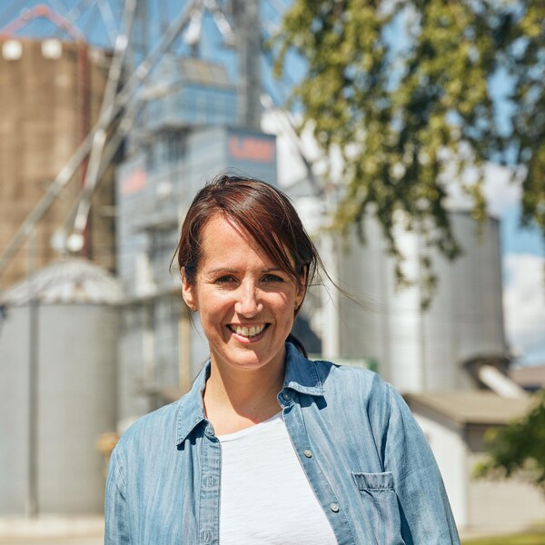 Geneviève O'Gleman pose devant une usine de grains située en Montérégie.