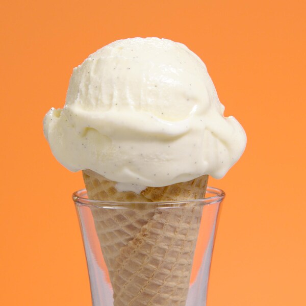 Un cornet de crème glacée à la vanille dans un support en verre.