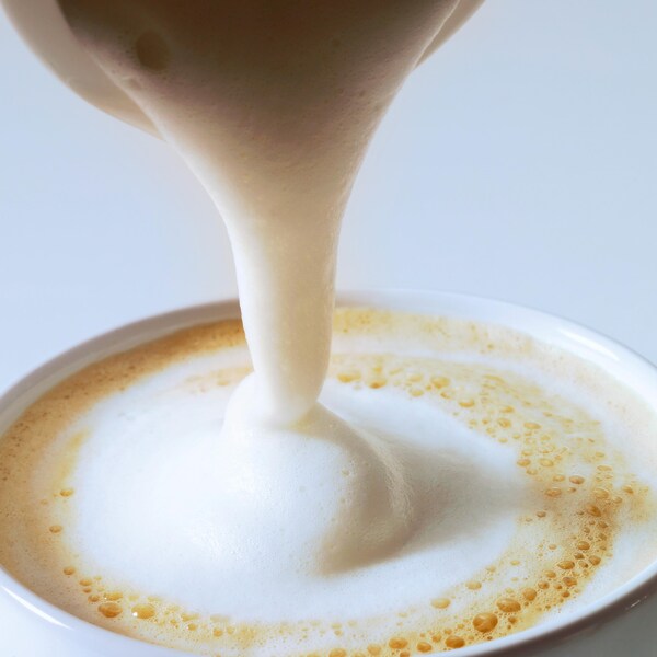 De la mousse de lait versée dans un café.