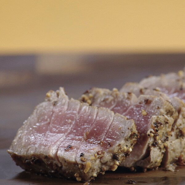 Un tataki de thon a été coupé en tranche sur une planche à découper. 