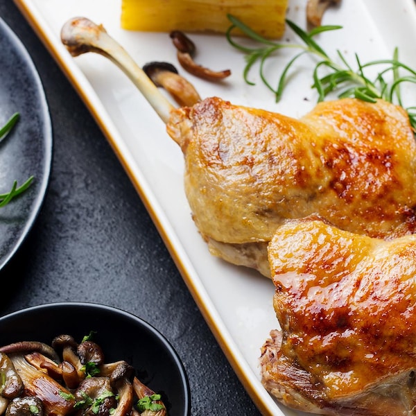 Deux cuisses de canard dans une assiette.