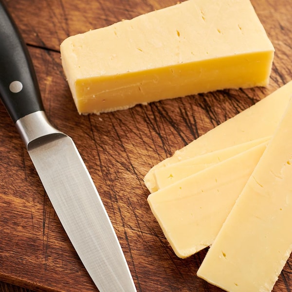 Un fromage à pâte ferme, tranché.