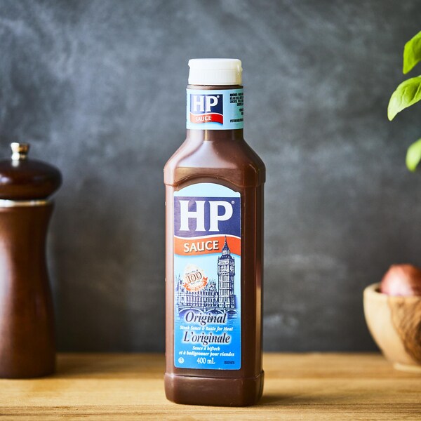 Sur une table, est déposé une bouteille de sauce à bifteck de type HP
