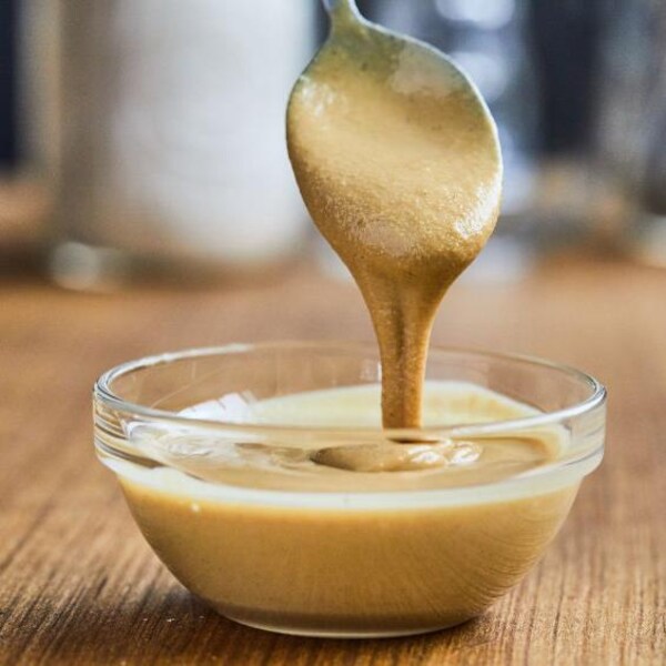 Un bol rempli de tahini avec une cuillère. 