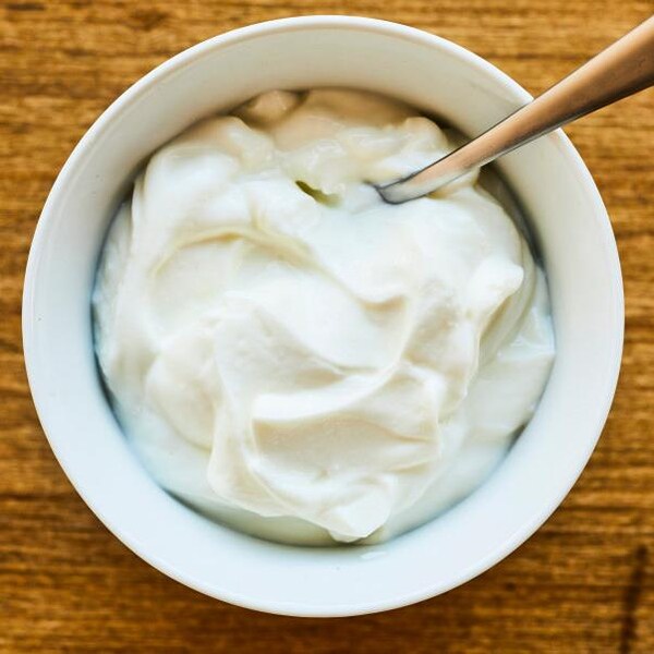 Un bol de yogourt grec avec une cuillère.
